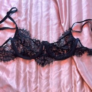 Small black lacy cupless bra.